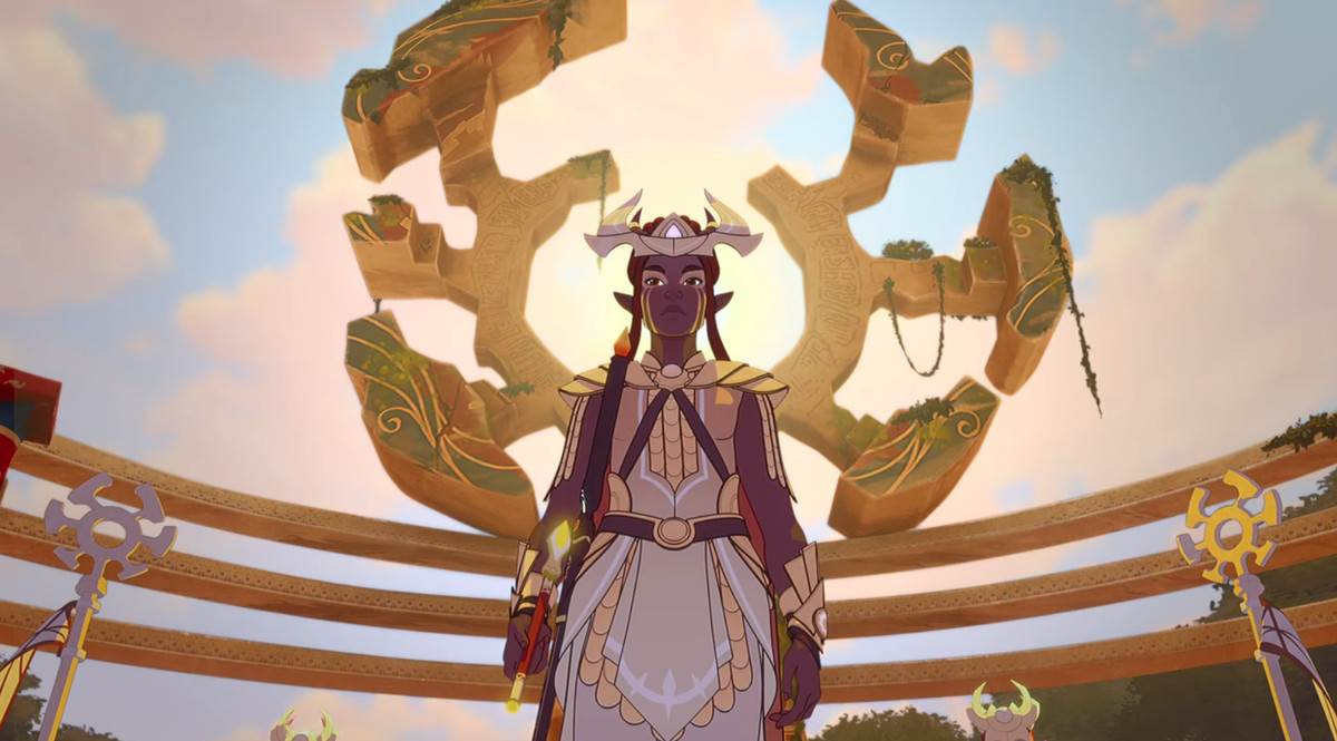 janai, una donna elfa dalla pelle scura con lunghi capelli rossi, si trova di fronte a un'aureola dorata; indossa un vestito bianco, il sole che illumina dietro di lei, e sembra potente ed eterea