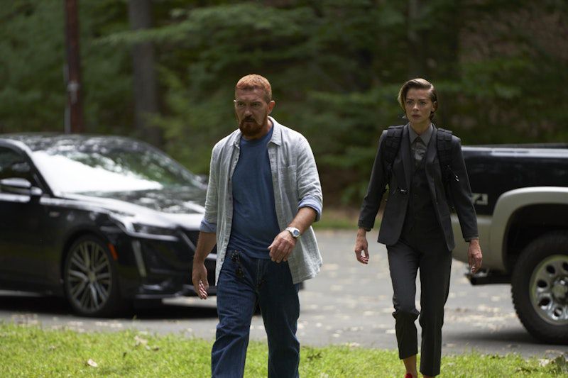 Un uomo con i capelli rossicci in camicia blu e blue jeans (Antonio Banderas) cammina accanto a una donna in abito nero (Jaime King).
