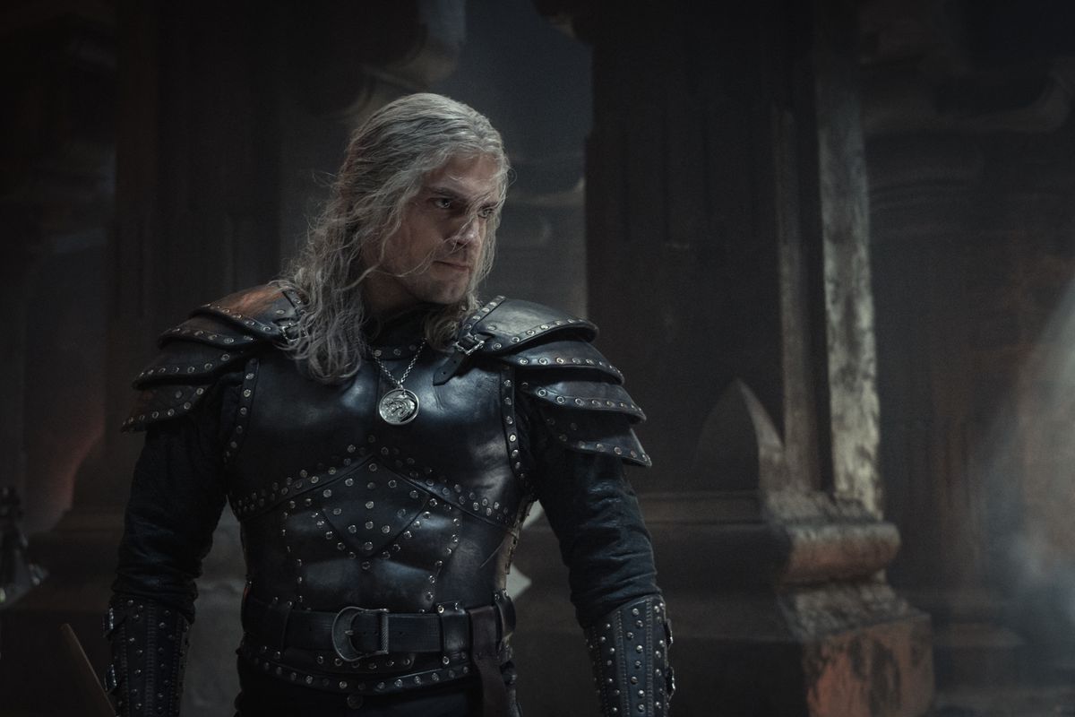 Henry Cavill posa in una grande armatura nera borchiata in un'area tipo castello, pronto a prendere a pugni un ragazzo in The Witcher