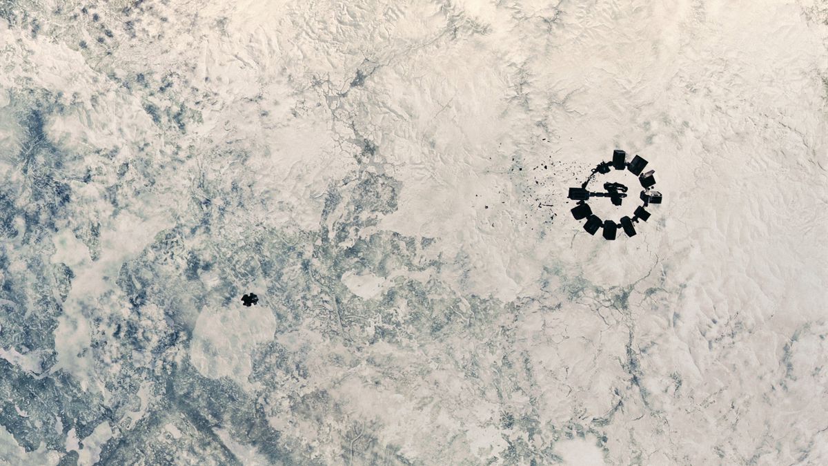 Una navetta si avvicina a un'astronave più grande sopra un pianeta alieno bianco e nuvoloso in Interstellar