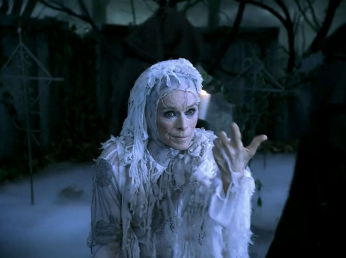 Una donna in vesti bianche a brandelli fa un gesto seducente con la mano in A Christmas Carol: The Musical (2004)