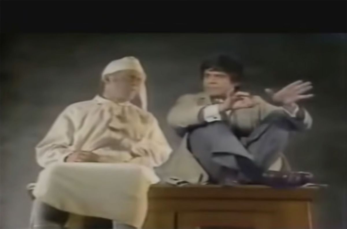 Scrooge nella sua vecchia camicia da notte opportuna seduto su una scrivania accanto a Natale Futuro, un uomo in trench