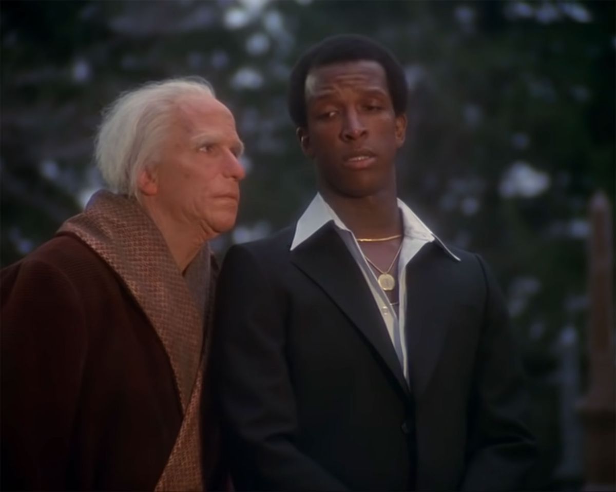 Henry Winkler truccato per la vecchiaia che interpreta Scrooge accanto a Dorian Harewood nei panni di Christmas Future