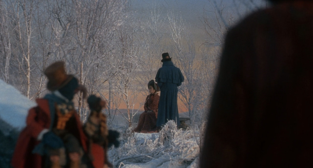 Gonzo, Rizzo e Scrooge guardano, invisibili, il sé più giovane di Scrooge e la sua fidanzata, Belle, seduti in un parco pieno di neve al tramonto.