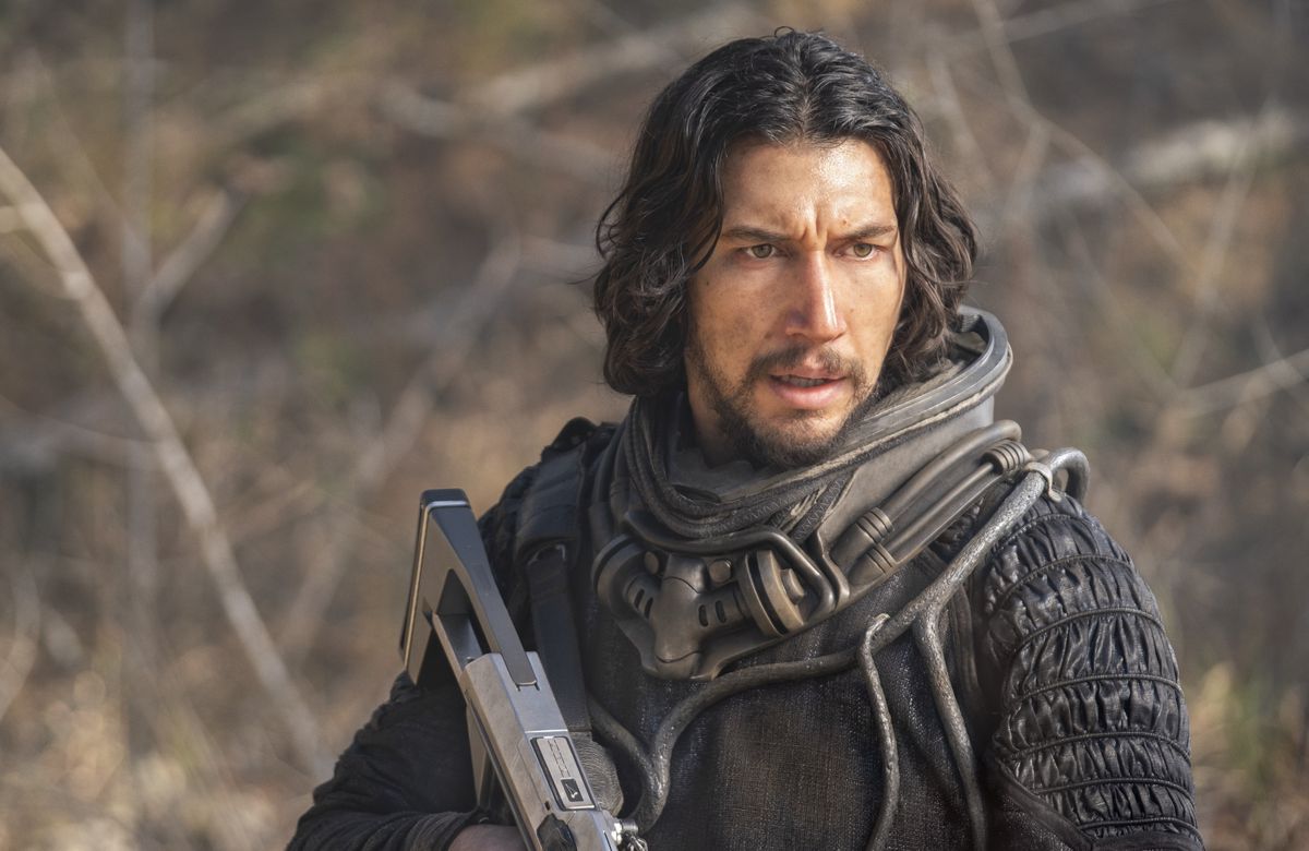 Adam Driver sembra spettinato e tiene in mano una pistola futuristica in 65