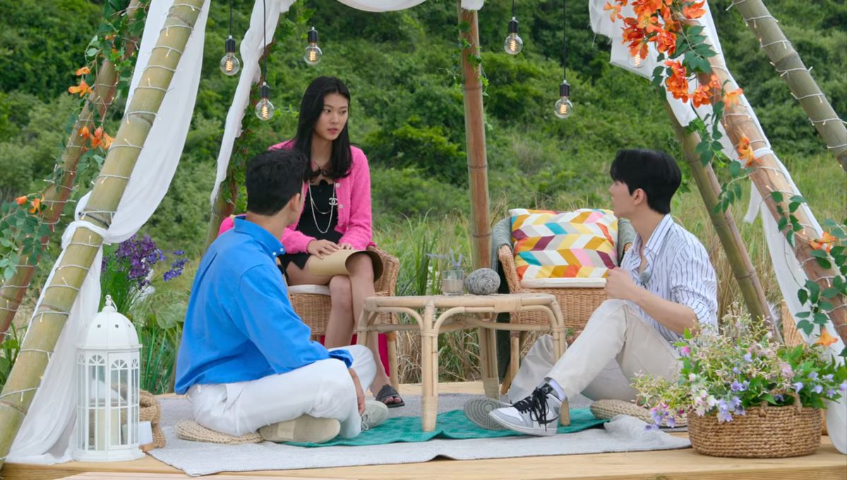 Tre concorrenti in Single's Inferno siedono insieme sotto un baldacchino.