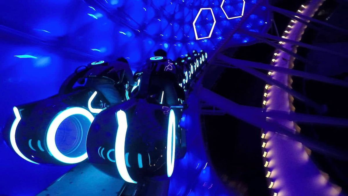 I motociclisti viaggiano su Tron Lightcycles attraverso un baldacchino blu nella versione Shanghai Disney di TRON Lightcycle / Run