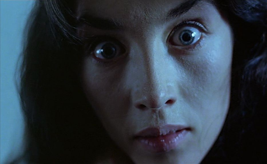 Un'inquadratura ravvicinata del volto di una donna (Isabelle Adjani) che fissa direttamente la telecamera con uno sguardo di frenetico orrore.