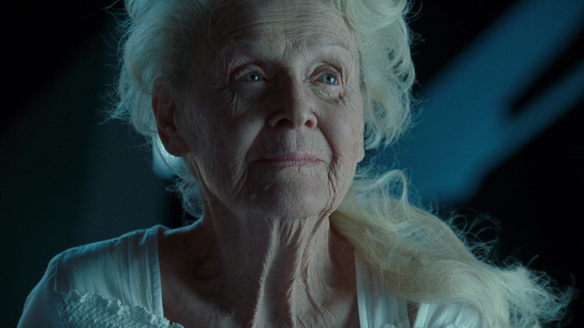 Rose (Gloria Stuart), in primo piano, è in piedi sul molo della barca del Titanic e fissa le stelle