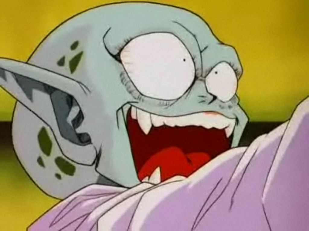 Una creatura anime calva e dalla pelle turchese pallida (Garlic Jr.) che ride maniacalmente con le zanne scoperte.