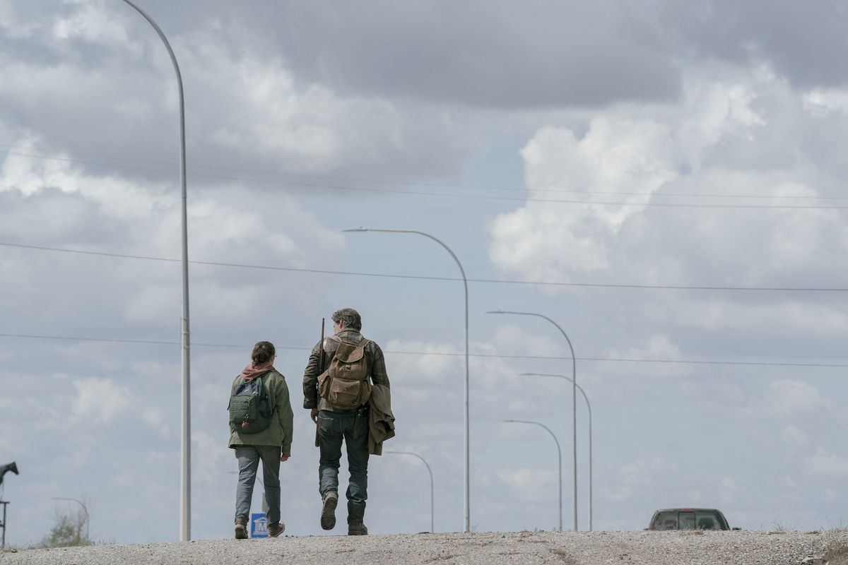 Joel ed Ellie si allontanano in lontananza con nient'altro che la strada e il cielo blu sopra di loro visibili in The Last of Us della HBO