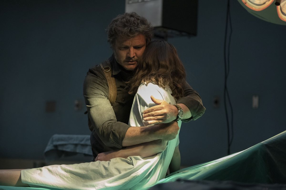 Joel solleva Ellie sulla sua spalla da un tavolo operatorio dell'ospedale in una scena di The Last of Us della HBO.