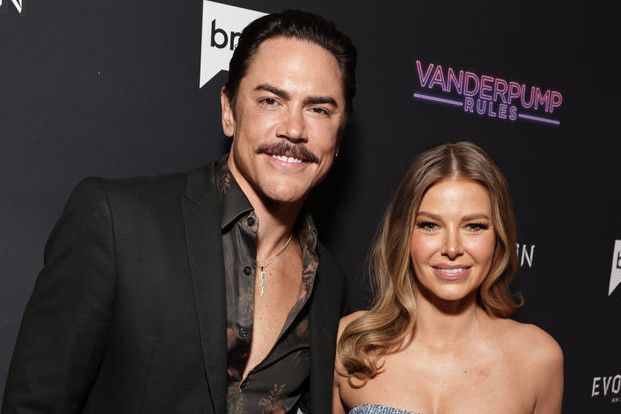 Tom Sandoval e Ariana Madix sorridono alla telecamera su un tappeto rosso per la prima festa della stagione 10 di Vanderpump Rules.