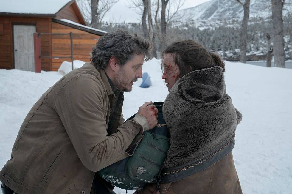Joel (Pedro Pascal) avvolge la sua giacca attorno a Ellie (Bella Ramsey) scossa e insanguinata nella neve