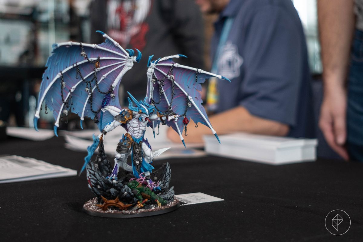 A white and blue drake stands on a table waiting to be placed under glass at AdeptiCon.