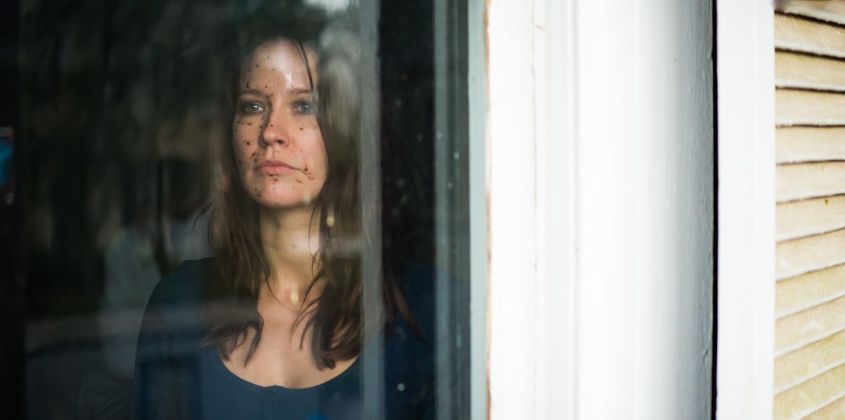 Anna Camp guarda fuori da una finestra in From Black.