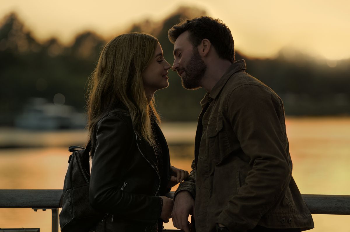 Cole (Chris Evans) e Sadie (Ana de Armas) si avvicinano per un bacio all'ora magica, un lago al tramonto dietro di loro sullo sfondo in Ghosted