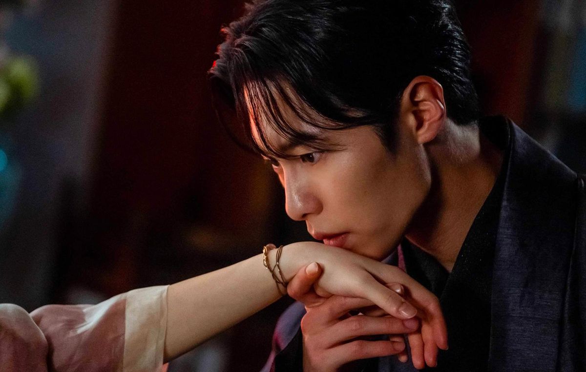 Un giovane posa le labbra sulla mano tesa di una giovane donna fuori campo in Alchemy of Souls.