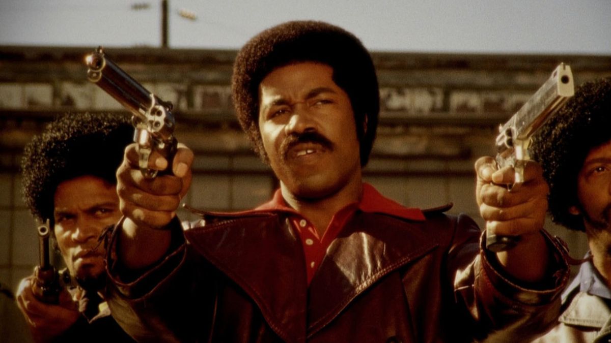 Michael Jai White che tiene in mano due revolver come Black Dynamite