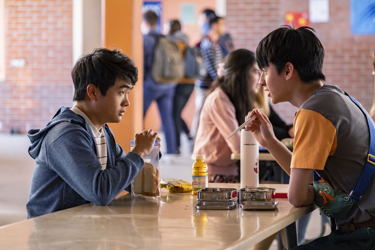 Ben Wang e Jim Liu nei panni di Jin Wang e Wei-Chen siedono l'uno di fronte all'altro al tavolo della mensa scolastica.  Jin ha un panino con pane bianco e succo di mela, mentre Wei-Chen ha cibo in scatola di metallo e sta mangiando con le bacchette. 