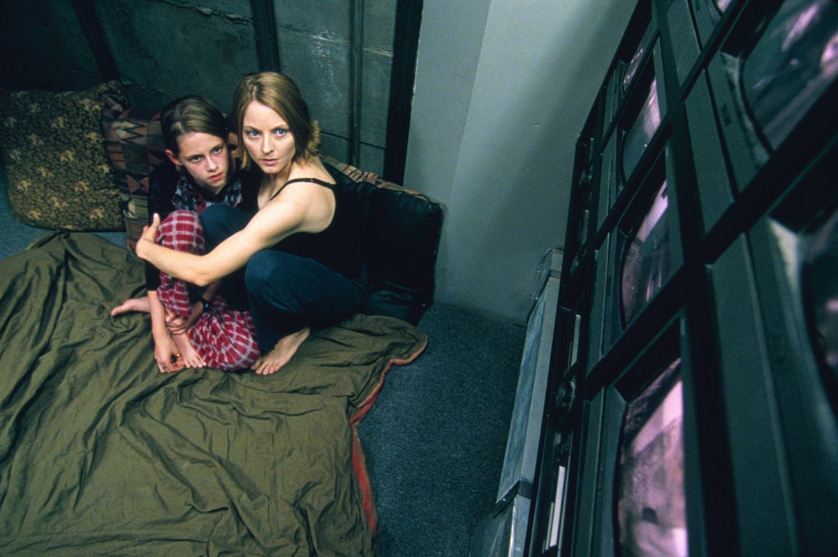 Jodie Foster e Kristen Stewart si stringono su una coperta verde mentre guardano una parete di schermi nella Panic Room.