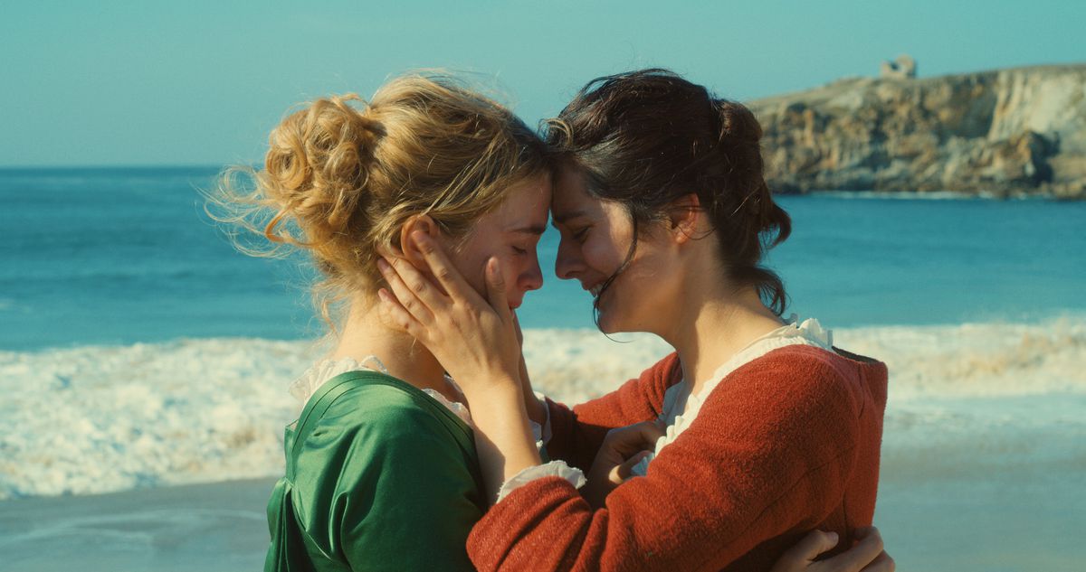 The two women hold each other close on the beach.