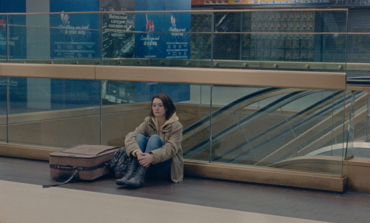 una giovane donna si siede sul pavimento della Penn Station
