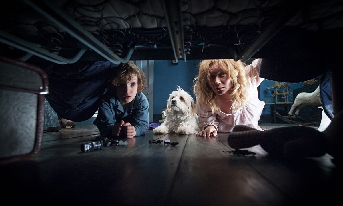 Essie Davis e Noah Wiseman sbirciano sotto il letto, cercando mostri in The Babadook.