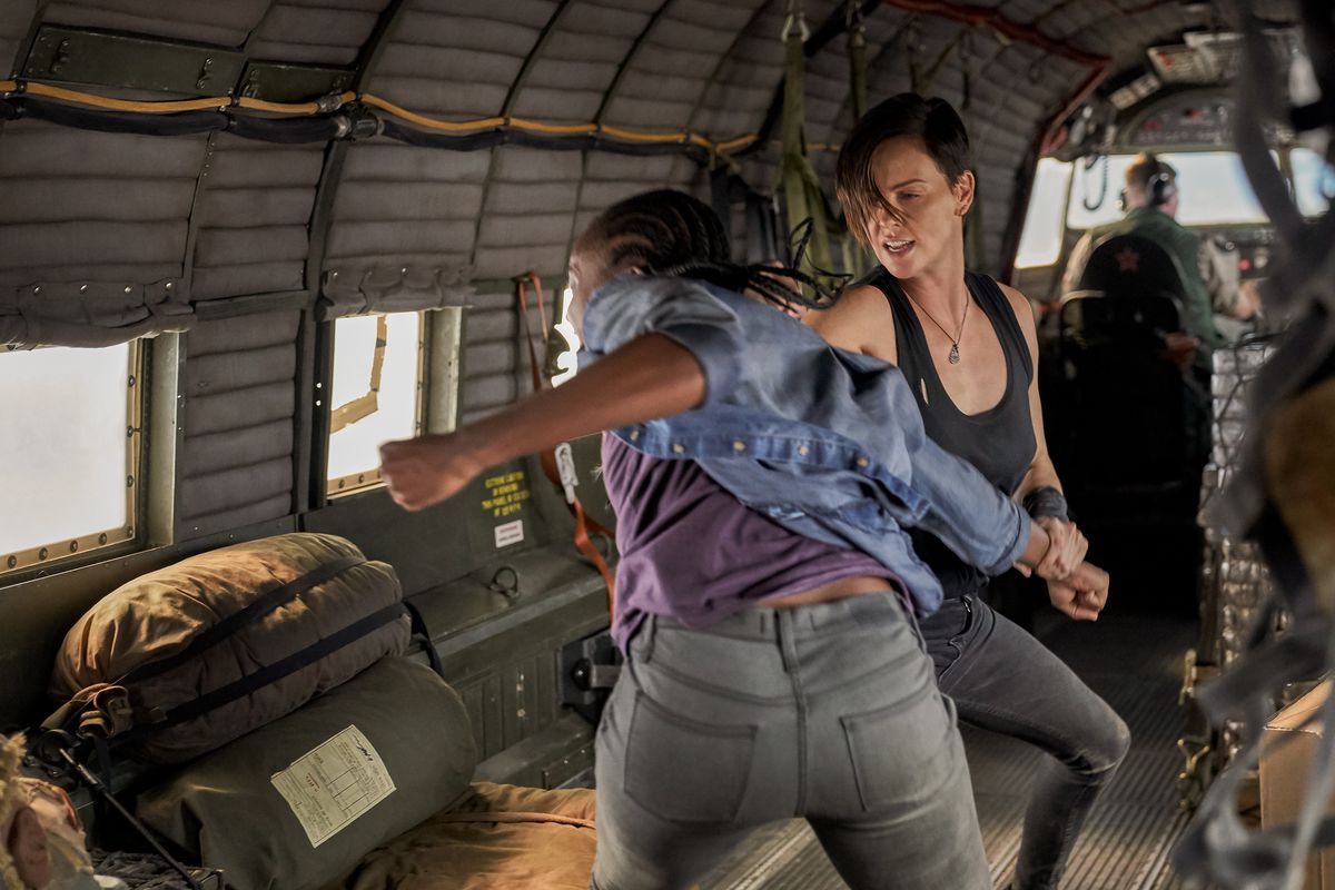 Charlize Theron e KiKi Layne si schioccano a vicenda su un aereo in The Old Guard.
