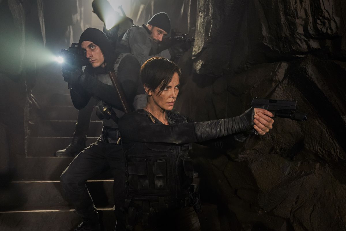 Charlize Theron conduce la sua squadra in un'area buia e sotterranea di The Old Guard.