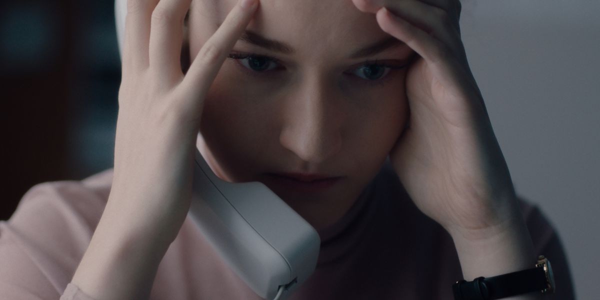 a woman on the phone holds her head in her hands