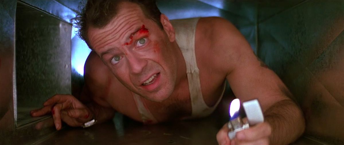 John McClane striscia attraverso un condotto d'aria in un fotogramma di Die Hard