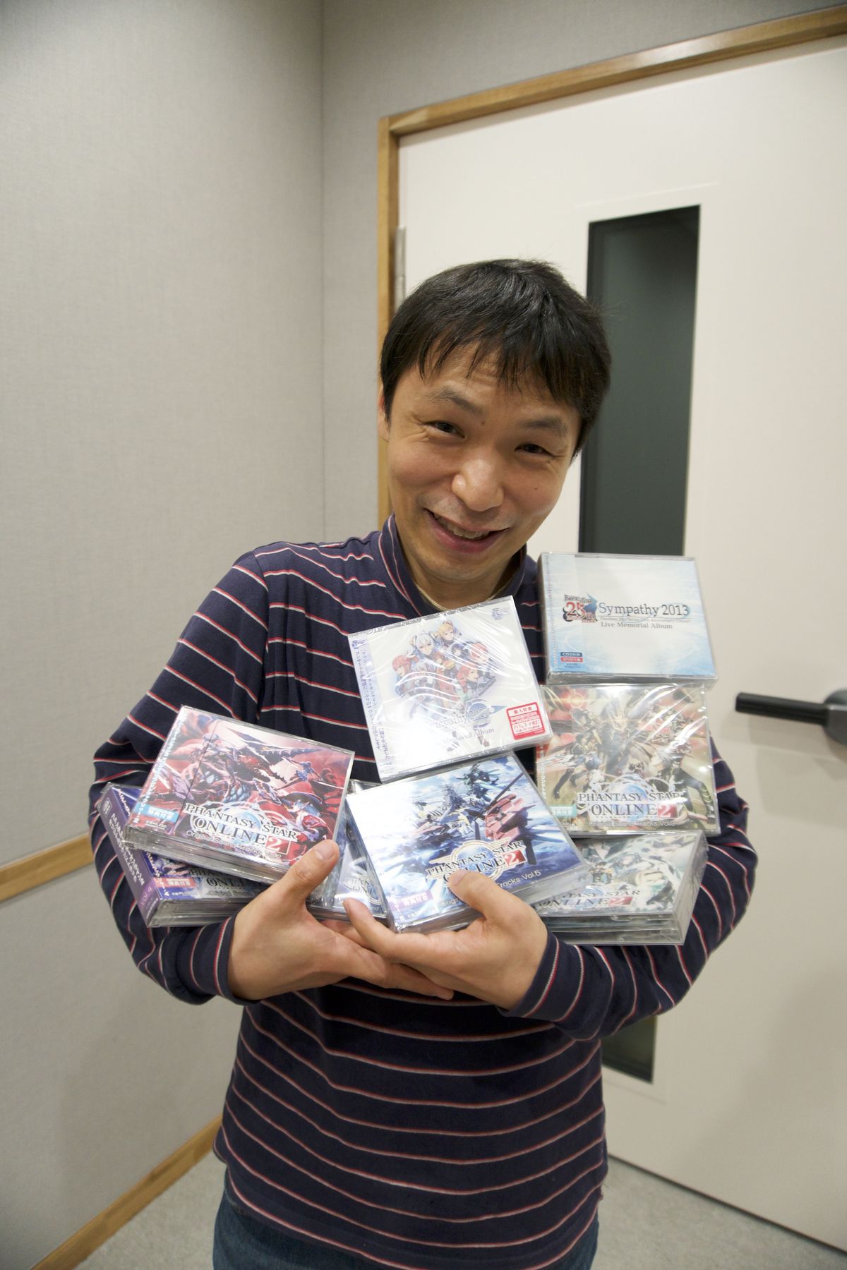 Hideaki Kobayashi trasporta una grande pila di custodie per CD