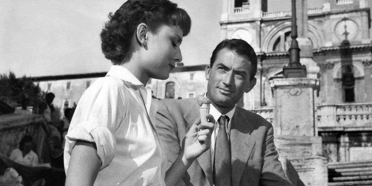 Audrey Hepburn mangia un cono gelato mentre Gregory Peck guarda in Vacanze romane