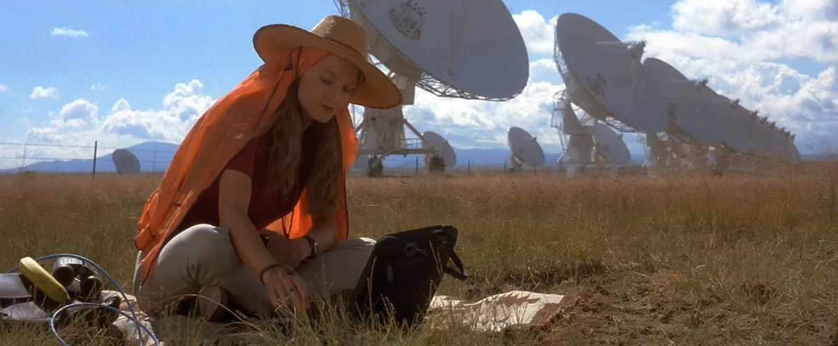 Jodie Foster seduta davanti alle antenne paraboliche in Contact
