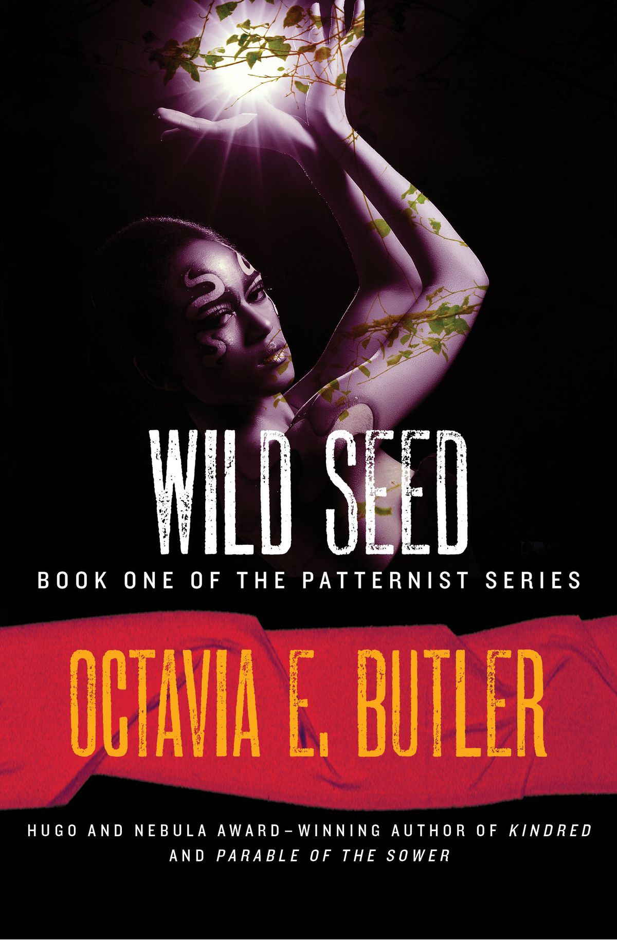 La copertina di Wild Seed di Octavia Butler, con una donna nera con serpenti tatuati sul viso che alza le mani e tiene le viti a coppa