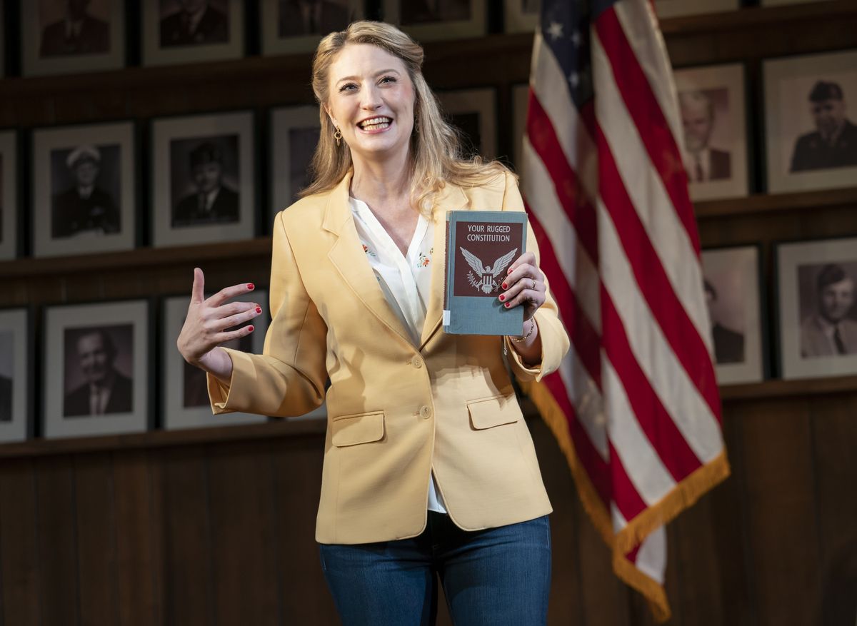 heidi schreck holds up a copy of the constitution