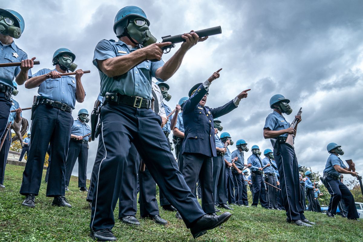 un gruppo di poliziotti che indossano maschere antigas