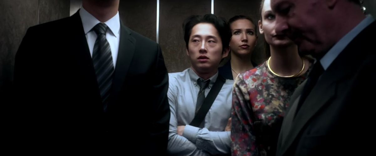 Un'immagine dal film Mayhem che mostra Steven Yeun in un ascensore affollato