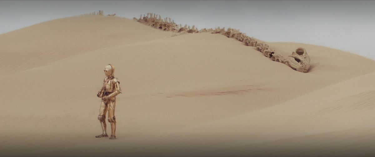C-3PO in piedi tra le dune di sabbia in Star Wars: Episode 4 A New Hope 