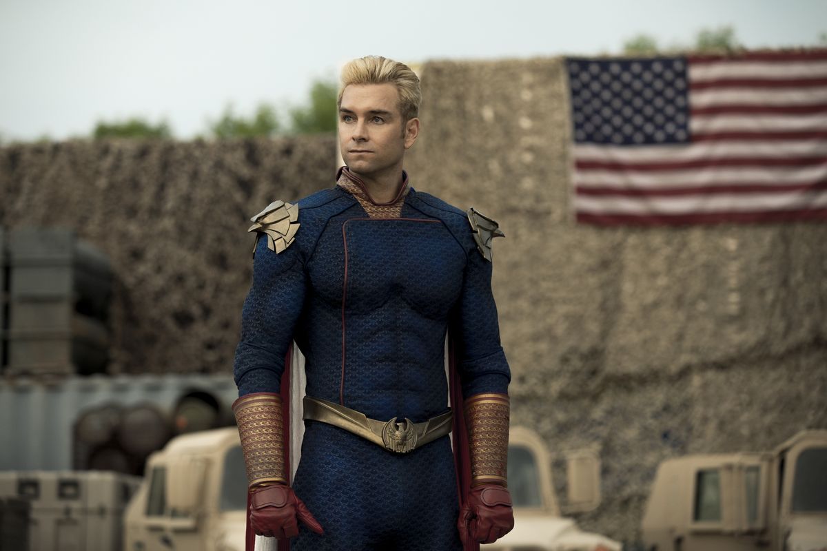 Homelander si trova su una base militare di fronte a una bandiera americana nella stagione 2 di The Boys