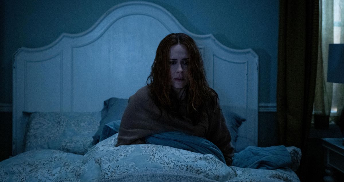 Sarah Paulson è seduta sul letto in una stanza buia in Hulu's Run