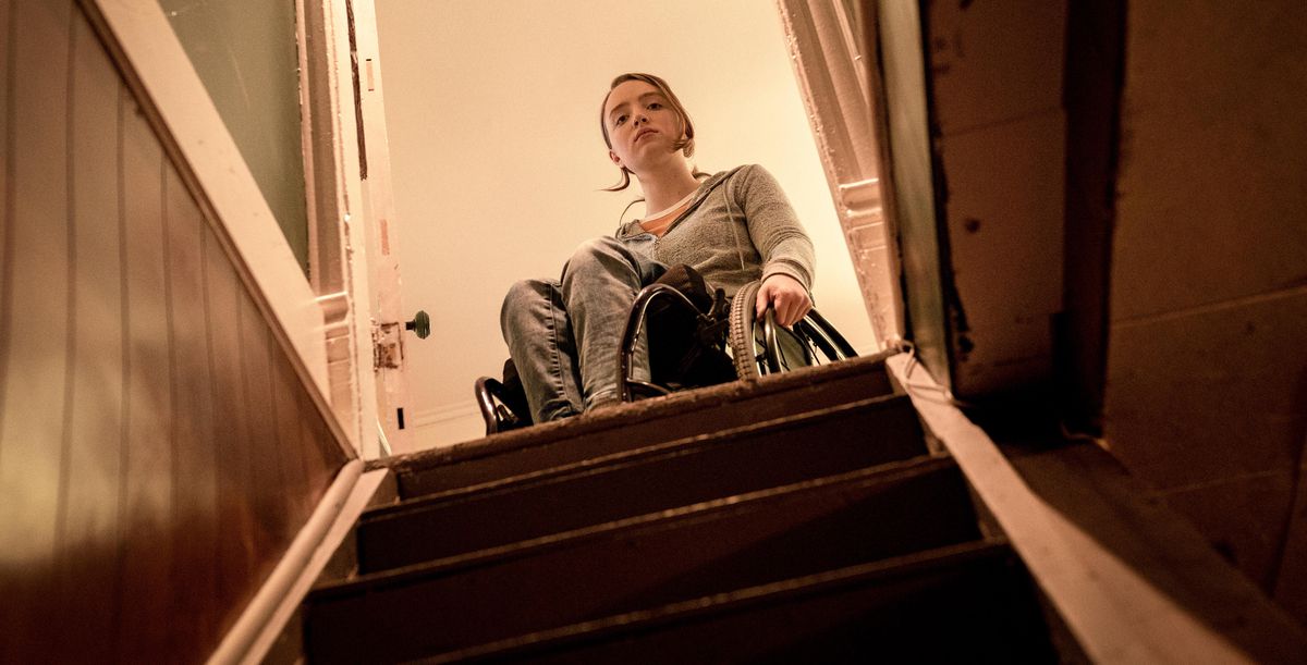 Kiera Allen, su una sedia a rotelle, si ferma in cima a una scala buia in Hulu's Run