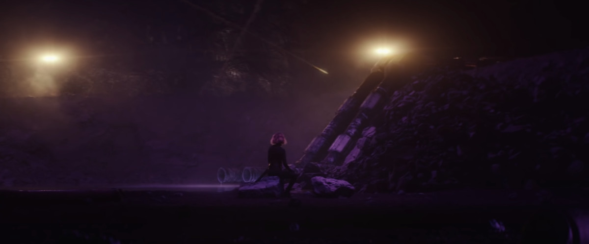 Una figura che sembra essere Black Widow siede su alcune macerie in un ambiente ultraterreno a Loki. 