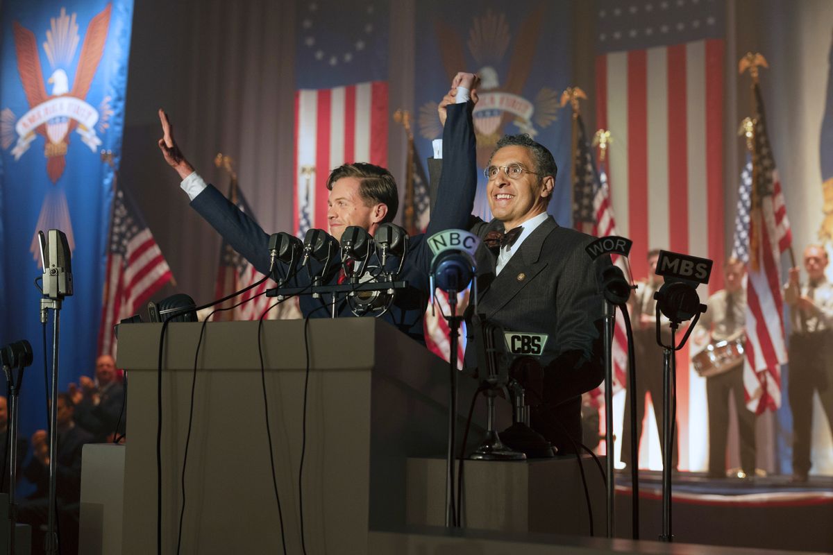 In 1940, in the alternative-universe setting of The Plot Against America, a rabbi played by John Turturro stands with a manic grin in front of a wall of American flags and “America First” banners, holding up the hand of a man who appears to be giving the Nazi salute.