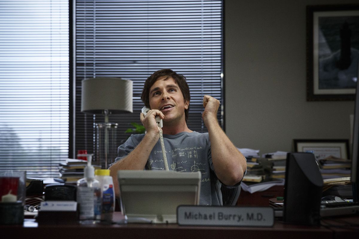 Michael Burry (Christian Bale) at his desk on the phone in The Big Short