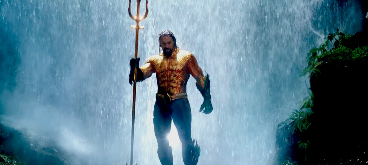Aquaman - Aquaman con in mano un tridente davanti a una cascata