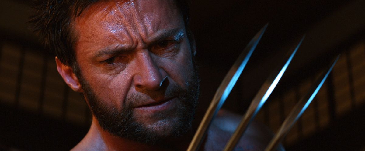 Wolverine è in piedi in primo piano tenendo il suo artiglio di metallo fino al viso