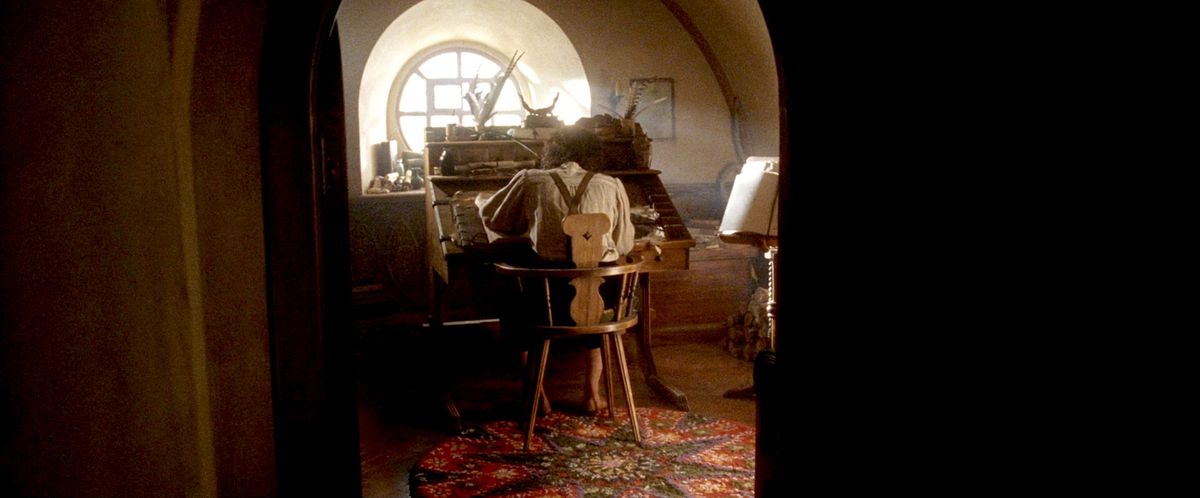 Frodo, back to camera, writes the Lord of the Rings at Bilbo’s sunlit desk in Return of the King