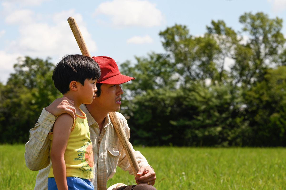 a korean father and his young son stand in an open field